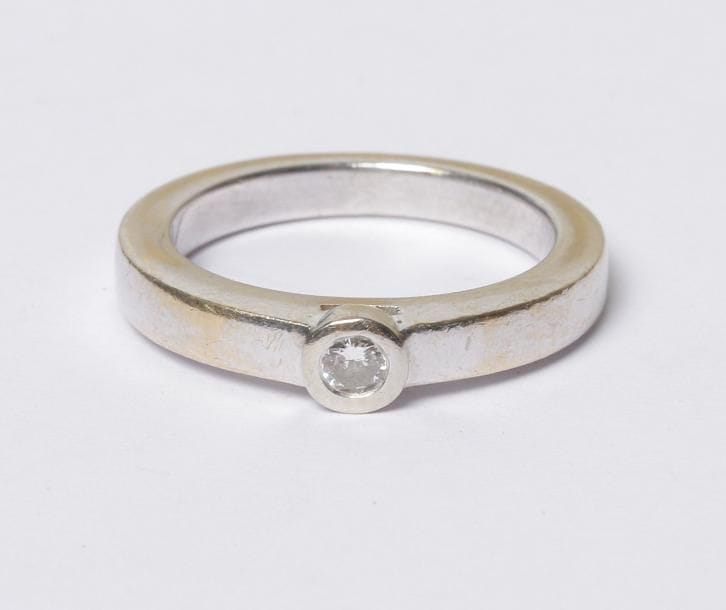 Bague en or gris 18K (750‰), ornée d'un diamant. Tour de doigt : 52. Poids brut : 7 g