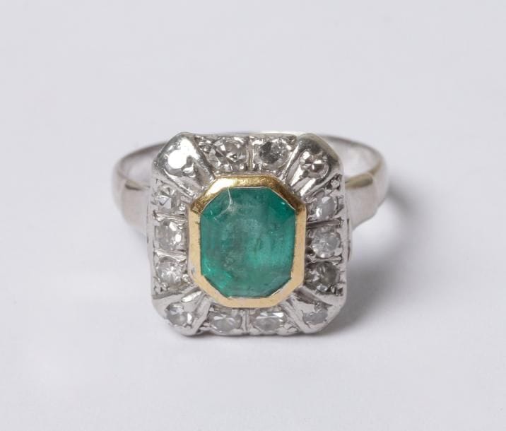 Bague en platine et or gris 18K (750‰), ornée d'une émeraude entourée de diamants. Tour de doigt : 50/51. Poids brut : 5,3 g