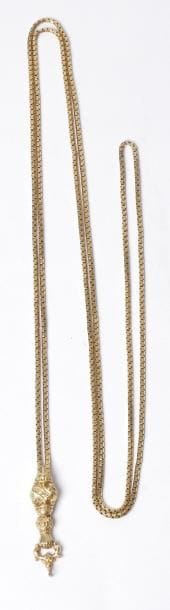 Chaîne giletière en or 18K (750‰), retenant un pendentif ciselé de feuillages terminé d'une main sculptée. Travail français de la fin du XIXe siècle. Poids : 28 g