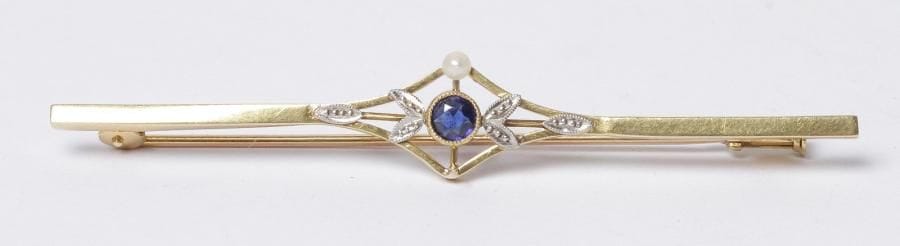 Broche-fuseau en or 18K (750‰), ornée d'une pâte de verre bleue. Poids brut : 3,3 g