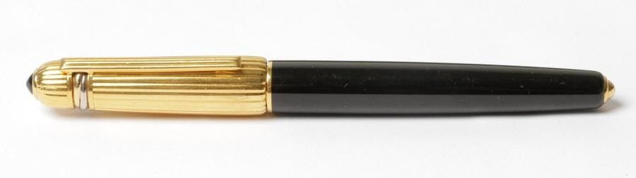 CARTIER
Stylo à bille modèle Pasha
Corps en résine noire et capuchon godronné plaqué or, 1989
Pierre en cabochon au sommet du capuchon
Numéroté 9630