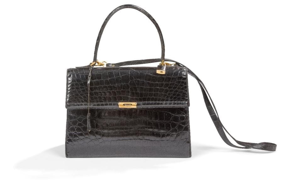Sac en veau verni façon croco noir. 4 poches intérieures. Clés, cadenas et bandoulière.
Larg. : 29 cm 
Bon état.