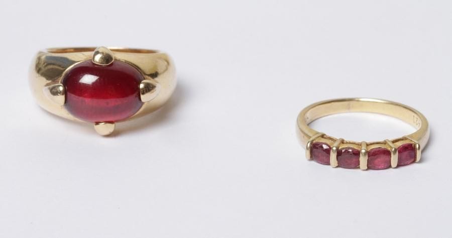 Bague en or 18K (750‰) ornée de 4 rubis. Tour de doigt : 53/54. Poids brut : 3,1 g. On joint une bague en métal doré, ornée d'un grenat cabochon.