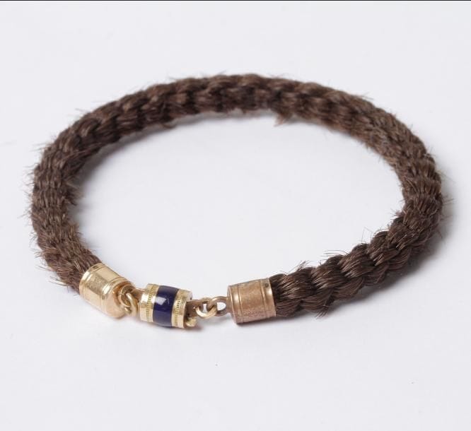 Bracelet en cheveux tressés, fermoir en or 14 K (585) agrémenté d'émail. Travail du premier quart du XIXe siècle. Poids brut : 3,6 g