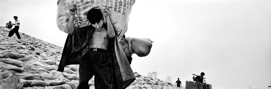 Zeng Nian (né en 1954)
Porteur à Chongqing, en arrière-plan la construction du nouveau port, 1998. Epreuve jet d'encre, titrée, signée, datée et numérotée 3/15 dans la marge inférieure, titrée et signée à la mine de plomb au verso. 61 x 135 cm avec les marges.