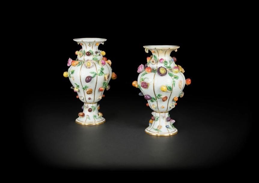 Allemagne
Paire de vases balustre en porcelaine dans le style de Meissen à décor polychrome et en relief de fleurs et fruits sur fond de vannerie.
Marqué : épées croisées en bleu.
XIXe siècle. 
H. : 36 cm
Quelques restaurations et manques