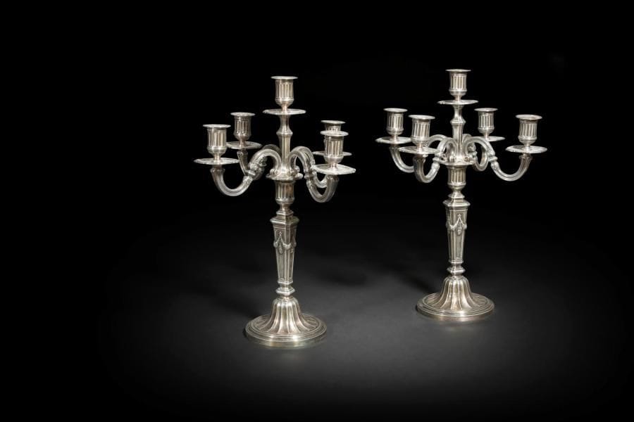 Paire de bougeoirs en bronze argenté à cinq bras de lumière, le piédouche à cannelures en rappel sur les binets, le fût à pans agrémenté de lauriers en chutes.
Style Louis XVI
H. : 45,5 cm ; D. : 14,4 cm