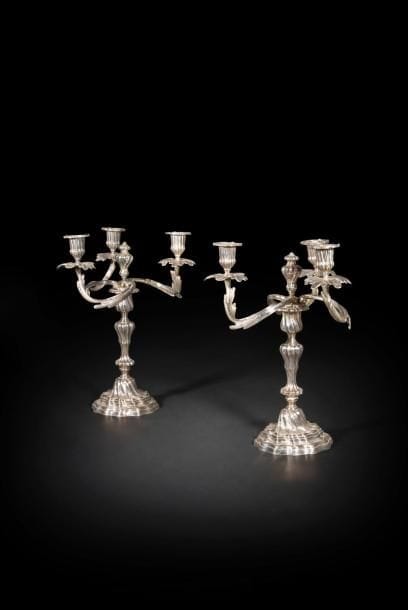 Paire de candélabres en bronze argenté, le bouquet amovible à trois lumières en enroulement reposant sur un fût à cannelures torses et base mouvementée.
Style Louis XV, XIXe siècle (usures)
H. : 36 cm ; L. : 27 cm