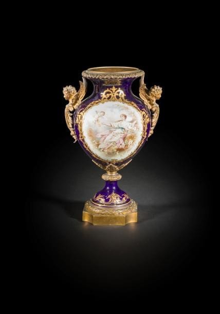 Vase en porcelaine polychrome sur fond bleu dans le goût de Sèvres, à décor de Vénus et l’Amour, signée G. Poitevin ; à monture de bronze doré à bustes d’enfant ailé
Fin du XIXe siècle
H. : 40 cm