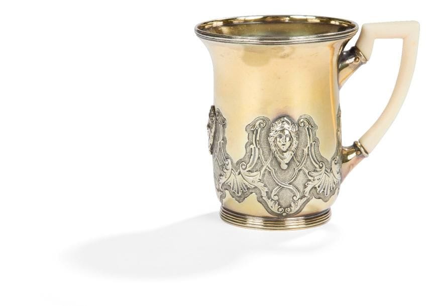 Belle tasse à thé en vermeil à anse latérale en ivoire, reposant sur une petite bâte moulurée de filets, elle est ciselée sur la moitié inférieure en repoussé sur fond amati de rinceaux et de trois mascarons dans des réserves en argent.
IRLANDE, BIRMINGHAM 1810
Orfèvre : Matthew BOULTON
Poids : 143,30 g - HAUTEUR : 8 cm