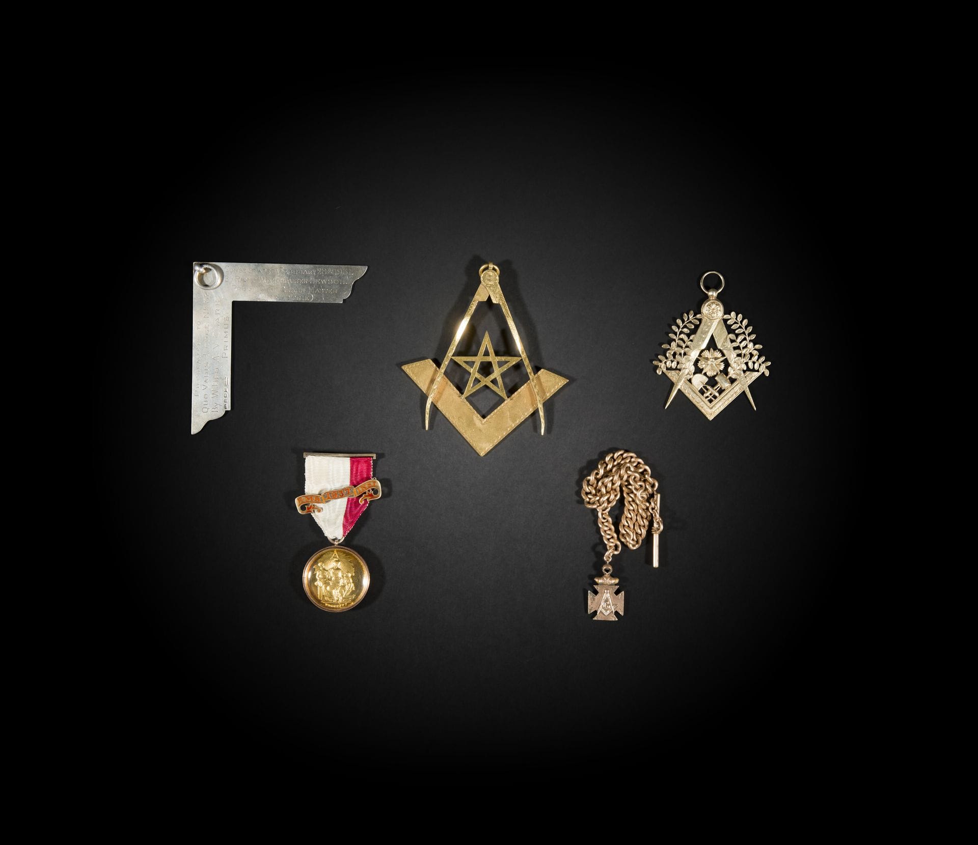 Lot de 4 bijoux maçonniques en argent, or et vermeil.
XXe siècle
Poids brut argent : 89,9 g - Poids brut  de l'or : 39,40 g
Et une chaîne de montre EN METAL avec médaille.