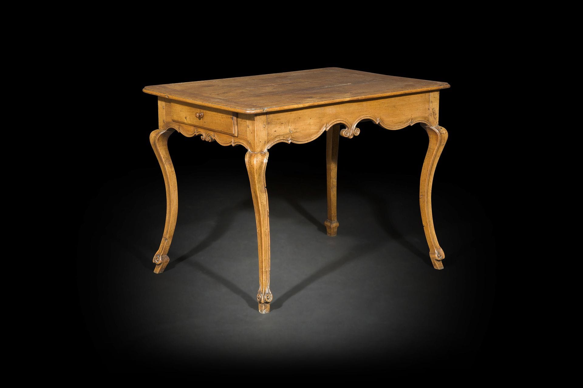 Table à écrire en noyer mouluré, la ceinture festonnée à volutes ouvrant à un tiroir de chaque côté reposant sur des pieds fortement cambrés terminés par des volutes.
Probablement Italie, milieu du XVIIIe siècle (accidents)
H : 74 cm, L : 98 cm, P : 71 cm