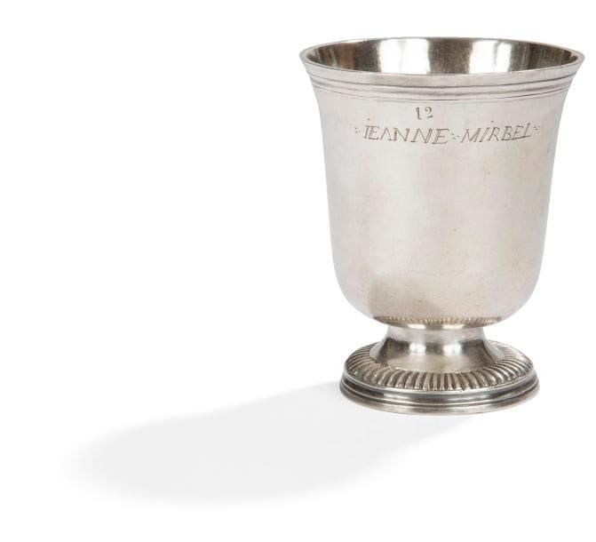 Timbale tulipe en argent reposant sur un piédouche mouluré de godrons, la coupe gravée « 12 JEANNE MIRBEL », la bordure évasée à rangs de filets.
CHALONS-EN-CHAMPAGNE, juridiction de REIMS vers 1745
Maître orfèvre : Henry CHARPENTIER.
Poids : 128,80 g - hauteur : 9 cm
