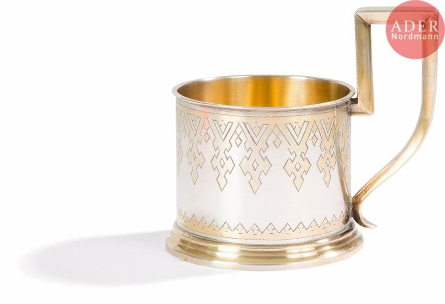 Porte-verre en argent et vermeil à décor gravé de motifs géométriques.
Poinçons : 84, Saint-Pétersbourg, 1878, essayeur « И Е » (essayeur non identifié de 1870 à 1891) et orfèvre « КВ » (Carl Werlin, fl. 1868-1878)
Hauteur : 9,5 cm, diamètre : 7,5 cm ; Poids : 130,62 g 

СЕРЕБРЯНЫЙ ПОДСТАКАННИК.
Серебро, гравировка, позолота.
Клейма: 84, Санкт-Петербург, 1878, пробирный мастер « И Е » (Неизвестный пробирный мастер 1870 - 1891), мастер « КВ » (Карл Верлин, упом. 1868-1878)
Высота : 9,5 см, диаметр : 7,5 см ; Вес : 130,62 г