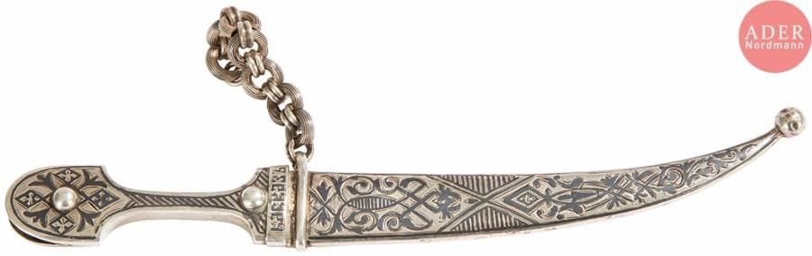Petit kindjal caucasien pour ceinture en argent 84 zolotniks (875 millièmes), à décor niellé de motifs stylisés et de l’inscription en russe Caucase, lame en acier, avec partie de chaîne d’attache (manques). Petites usures.
Saint-Pétersbourg, vers 1870-1880.
Orfèvre : OK, non répertorié.
L. 20 cm. Poids brut : 62,9 g

