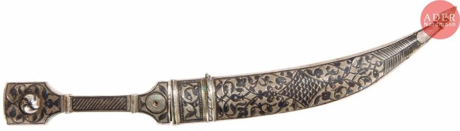 Petit kindjal caucasien pour ceinture en argent 84 zolotniks (875 millièmes), à décor niellé de rinceaux feuillagés et de l’inscription en russe Caucase, lame en acier, dos gainé de velours rouge. Manques, en l’état.
Probablement Novotcherkassk, vers 1850.
L. 22 cm. Poids brut : 44,7 g

