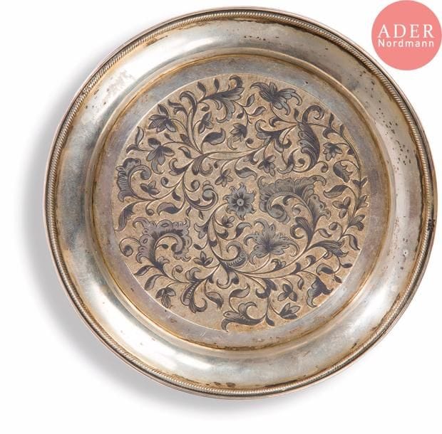 Soucoupe ronde en vermeil 84 zolotniks (875 millièmes), à décor niellé au centre dans un médaillon de rinceaux feuillagés sur fond amati, les bords relevés. Usures.
Moscou, 1849.
Orfèvre : AF en cyrillique, non repertorié.
D. 14,5 cm. Poids brut : 153,3 g

