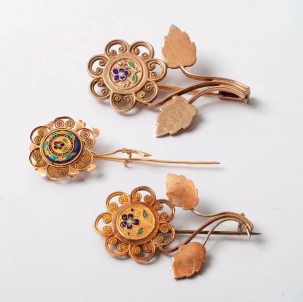 Lot de 3 broches en métal ou en argent sommées chacune d'une fleurette émaillée. Travail français du XIXe et du XXe siècle. (manques)