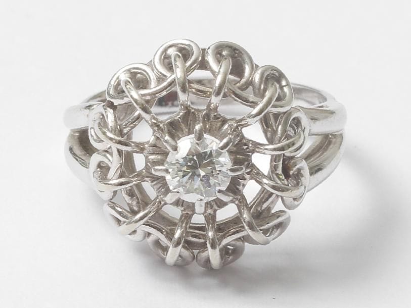 Bague en fils d'or gris 18K (750), ornée d'un diamant pesant environ 0,20 ct. Tour de doigt: 50. Poids brut: 4,7 g