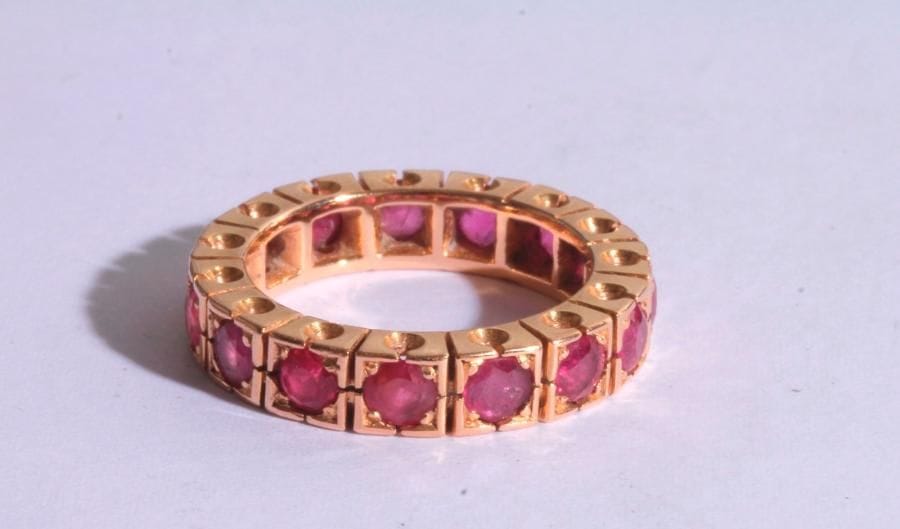 Alliance en or rose 18K (750‰), entièrement sertie de rubis. Tour de doigt : 54. 

Poids brut : 8,2 g 

(égrisures)