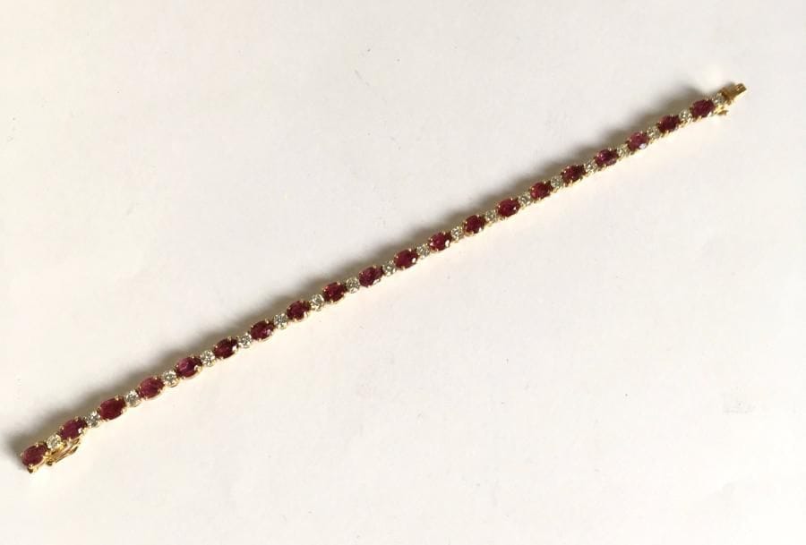 Bracelet ligne en or 18K (750), orné de diamants scandés de rubis (traités) ovales. Poids brut: 15,3 g