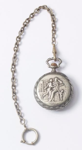 Montre de poche en métal argenté sur fond scénes des Misérables. Boîtier ouvragé, cadran émaillé, chiffres romains, chifrres rouges en 24 H. Trotteuse à 6 H et chaîne en métal trés usée, ressort cassé.