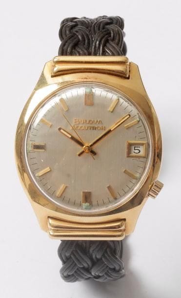 BULOVA. Montre bracelet d'homme en or 750/1000, accutron (électronique à dypason, à quartz). Cadran argenté avec appliques, date à 6H. Bracelet tressé et son fermoir en or.

Poids brut : 53,30 g