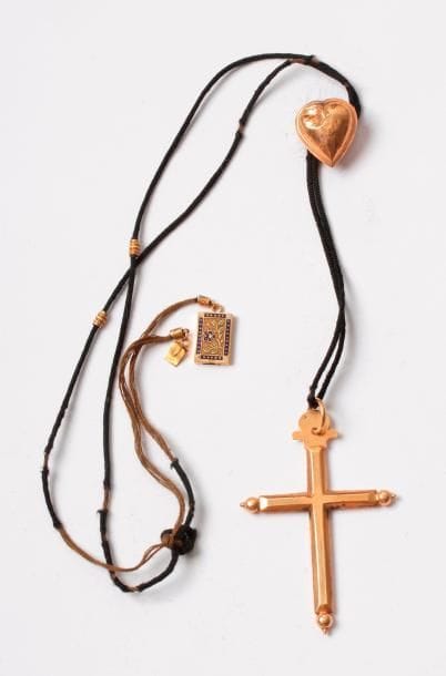 Croix-pendentif en or 18K (750) coulissant sur un lien agrémenté d'un cœur coulant en or, de deux viroles et d'un fermoir en or agrémenté d'émail. Travail du premier quart du XIXe siècle. Poids brut: 6 g (enfoncements)