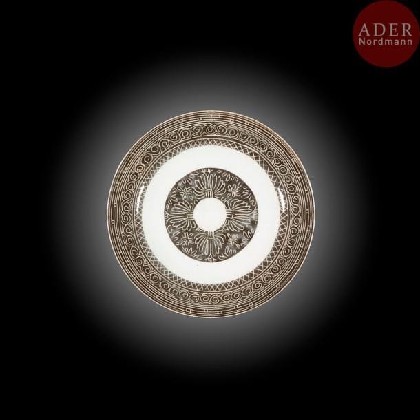 Deux assiettes aux motifs floraux, Iran, Naïn, fin XIXe siècle
Céramique sur petite base à décor brun sur fond blanc, de médaillons circulaires évidés, l’un à décor de tulipes et de cartouches floraux au rebord ; l’autre orné d’arbustes. Sur le pourtour plusieurs frises à motifs géométriques, au dos une incision indique une marque d’artisan « amal Mohammad » et une date « 128[6]H./1869 ». 
Diam. : 23,8 cm; 24 cm
Two pottery dishes, with floral motifs, Iran, Naïn, late 19th century.