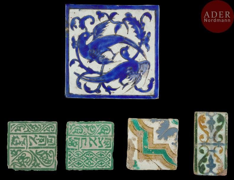 Cinq carreaux de revêtements, Espagne, Maroc et Iran, XVIIe – XIXe et XXe siècle
- Deux carreaux, à décor cuenca y arista, moulés en polychromie de palmettes ou de motifs géométriques (manques, une partie recollée) ; - deux petits carreaux carrés à décor excisé sur glaçure verte d’une inscription hébraïque sur l’un « à l’entrée » et sur l’autre « à la sortie », bordée de tresses de rinceaux de palmes et fleurons ;
- un carreau persan, à décor peint en bleu sur fond blanc de deux oiseaux sur un fond de tige végétale. 
Dim. : 11 x 11,5 cm ; 10,5 x 10,5cm ; 14 x 7,5 cm ; 20,5 x 20 cm
Five different ceramic tiles, Spain, Morocco and Iran, 18th- 19thand 20th century.