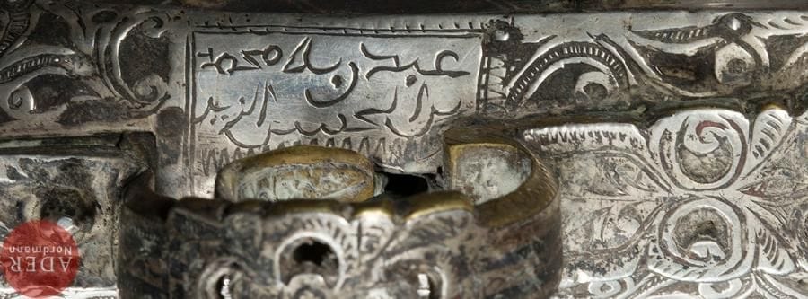 Fusil à silex, mukhala, Afrique du Nord, signé et daté 1869
Long canon en bois à bagues d’argent dont certaines ciselées de fleurs, crosse en os, à garnitures d’argent ciselées de rinceaux et cloutées. Baguette. Sous la platine, inscriptions donnant le nom du fabricant « Mohammad ibn al-Hossein al-Zeyd » et la date « mois de Chavval 1286 H. / 1869 ».
Long. : 162 cm
A flintlock pistol, mukhala, North Africa, signed and dated 1869
