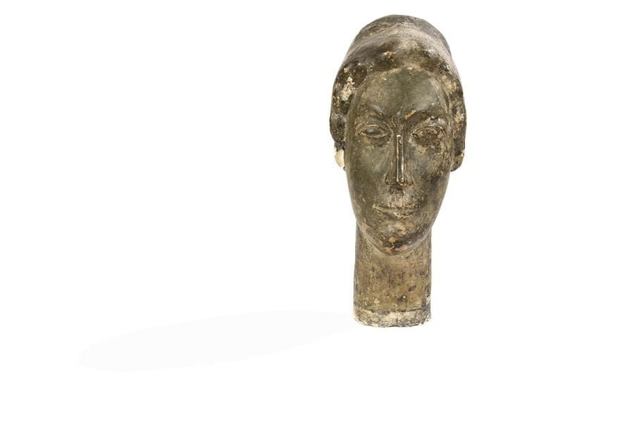 Hortense BEGUé (1892-1955)
Tête de femme, 1913
Plâtre patiné.
Signée et datée.
(Usures de patine et petits accidents).
Hauteur : 43 cm

Plus connue comme sculpteur animalier dans les années 20-30, Hortense Begué, née en 1892, fréquente dès son plus jeune âge le Montparnasse artistique. Elle y rencontre Celso Lagar, peintre espagnol qui s’établit à Paris au début des années 10, dont elle devient la femme. Ils côtoient tous deux André Derain, Fernand Léger, Max Jacob, et Amedeo Modigliani qui peint le portrait de Lagar en 1915. Datée de 1913, cette tête de femme de forme ovale allongée, ses yeux en amande, son nez fin et long à l’arête saillante rappellent les traits de certains dessins et sculptures de Modigliani des années 1910-13, époque où le maître est fortement influencé par ses rencontres avec l’art khmer, cycladique ou égyptien.