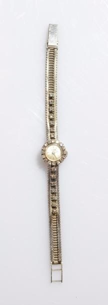 PELLEGRIN. 
Montre de dame en or gris 18K (750 ‰), cadran rond serti de diamants, index bâtons, bracelet souple en or 18K agrémenté de 14 diamants, mouvement mécanique. 
Longueur : 14,5 cm environ.
Poids brut : 25,6 g