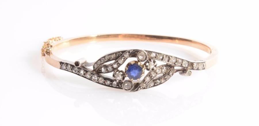 Bracelet en or 18K (750 ‰) et argent, orné d’un motif ajouré serti d’une pierre bleue et de diamants taillés en roses. Travail français de la fin du XIXe siècle.
Poids brut : 12,9 g