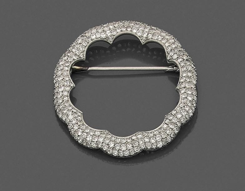 Broche festonnée en platine, pavée de diamants. 
Diamètre : 4,9 cm environ.
Poids brut : 14,6 g