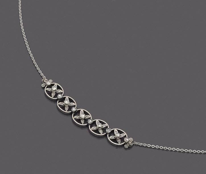 Collier en or gris 18K (750 ‰), orné au décolleté de 5 motifs ovales sertis d’un croisillon de diamants taillés en roses. 
Longueur : 42 cm environ.
Poids brut : 13,1 g
