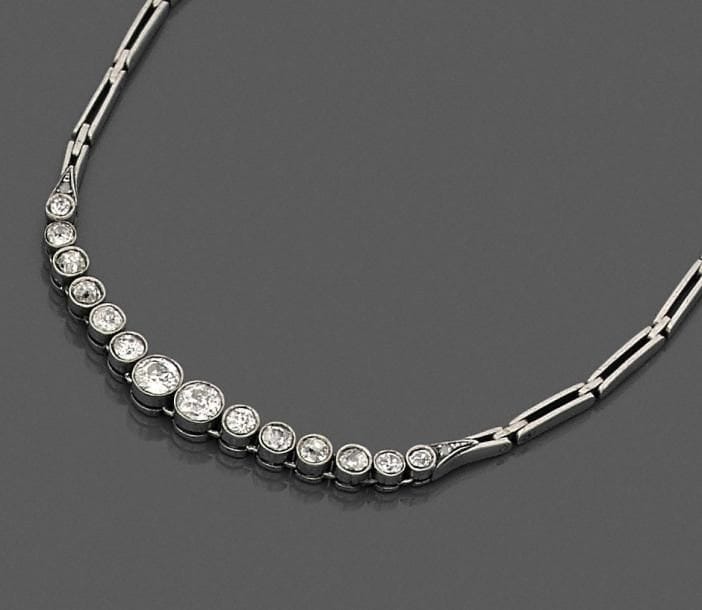 Bracelet en or 18K (750 ‰) et argent, orné d’une ligne de 14 diamants de taille ancienne en chute. 
Longueur : 18 cm environ.
Poids brut : 6,7 g (égrisures, chocs)