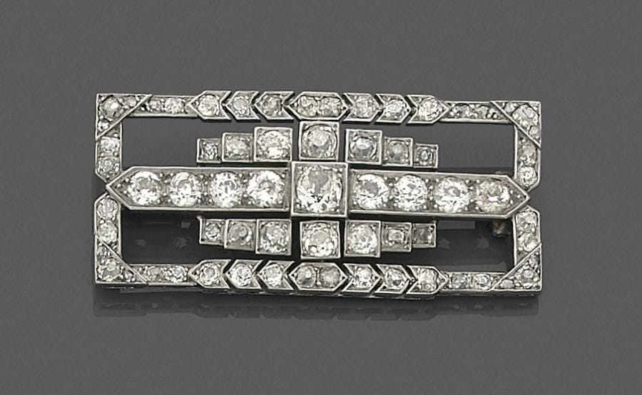 Broche en platine et or gris 18K (750 ‰) formant des motifs géométriques imbriqués sertis de diamants de taille ancienne. Travail français des années 1930. Dimensions : 2 x 4,5 cm environ.
Poids brut : 12,1 g
