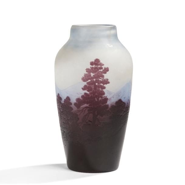 Établissements GALLÉ (1904-1936)

Paysage vosgien
Vase balustre à large col annulaire.
Épreuve en verre multicouche au décor tournant, dégagé à l’acide, traité bleu pâle et indigo sur fond gris-blanc nuancé de bleu.
Une infime égrenure (tête d’épingle) en pourtour.
Signé GALLÉ, en réserve gravé en camée à l’acide.
Hauteur : 18,8 cm