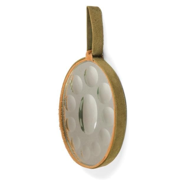 TRAVAIL des ANNÉES 1950 / 60 dans le goût de Piero FORNASETTI (1913-1988) 

Miroir à suspendre de forme ovale et à l’encadrement en cuir fauve et nubuck vert.
Le miroir est constitué d’une sorcière ovale encadrée de dix sorcières rondes.
Petits frottements et usures sur les parties en peau.
Hauteur : 37 cm

Provenance :
Collection de M. et Mme B., Dannemois (Essonne – France). Œuvre acquise à l’époque.