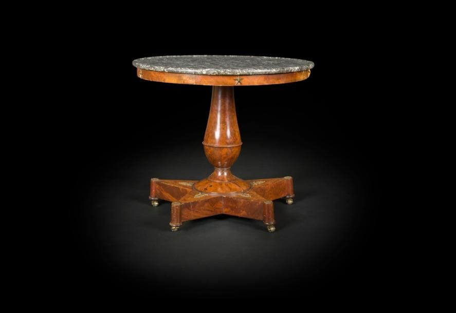 Guéridon en acajou flammé, le plateau de marbre gris Sainte Anne à rebord reposant sur une fine ceinture et un fût en balustre mouluré à plinthe en forme d’étoile à cinq branches.
Début du XIXe siècle.
H : 70 cm, D : 82 cm
