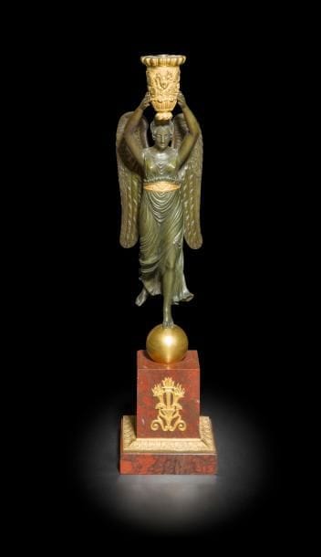 Figure de Victoire formant flambeau en bronze patiné et bronze doré, reposant sur une base en marbre rouge Griotte à brandons de bronze doré ; (manque probablement le bouquet).
Époque Empire
H : 58 cm