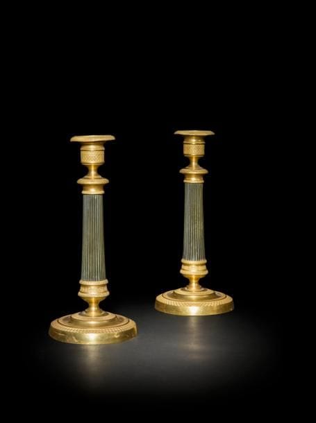 Paire de flambeaux en laiton patiné et doré, à fût à cannelures et base circulaire guillochée.
Époque Restauration
H : 25,5 cm