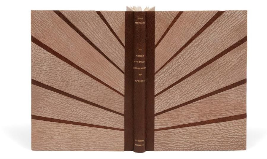 [SERVEAU (Clément)] - BERTRAND (Louis).
La Femme qui était retournée en Afrique.
Paris : Le Livre, [1920]. — In-8, 227 x 157 : (6 ff. 2 premiers blancs), 79 pp., (4 ff. 3 derniers blancs), couverture illustrée. Chagrin marron, plats ornés de 6 larges bandes obliques de peau de buffle grège, dos lisse, doublures de chagrin marron, gardes de velours gris, non rogné, couverture et dos conservés, chemise à recouvrement doublée de velours gris et étui (Dominique Comolli).
Charmante édition illustrée de bois originaux dans le texte et à pleine page du peintre, illustrateur et graveur Clément SERVEAU (1886-1972).
Tirage à 528 exemplaires?; celui-ci est l’un des 500 sur papier vélin d’Arches.
Exemplaire superbement relié. La reliure bien que non signée, est de Dominique Comolli.