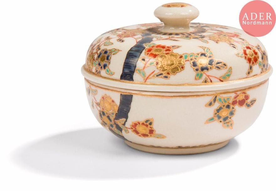 JAPON, Fours de Satsuma
Époque MEIJI (1868 - 1912)
Petite boîte ronde en faïence de Satsuma émaillée polychrome et or d’arbre de cerisier en fleurs, l’intérieur orné de papillons en vol.
H. : 6,3 cm. 