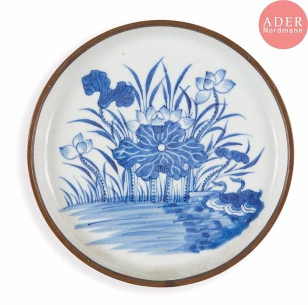 VIETNAM, Hue - XVIIIe / XIXe siècle 
Coupe en porcelaine décorée en bleu sous couverte d’un couple de canard nageant parmi les fleurs de lotus. Marque Wan Yu. (Fêlure, bord cerclé de métal, fêlures). 
Diam. : 17 cm