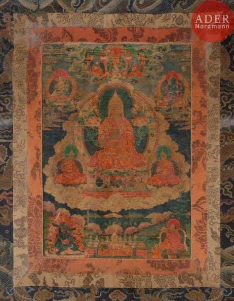 TIBET - XVIIIe siècle
Tangka, détrempe sur toile. Le lama Tsongkhapa, dans un médaillon central, assis en padmasana les mains en vitarca mudra tenant le livre et lotus, des lamas de la secte gelupta de chaque côté, tara et bouddha en partie supérieure, une divinité féroce et un moine en partie inférieure. (Usures et pliures).
Dim. : 40 x 29 cm. Encadré sous verre.