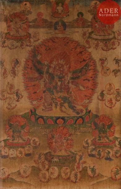 TIBET - XVIIIe siècle
Tangka, détrempe sur toile. Déités du Bar-do, Hayagriva en furie à trois têtes et six bras les ailes ouvertes, tenant le damaru, le Khatvanga, le vajra, le ghanta, le kapala, debout en yab-yum avec sa satki sur le lotus au centre, devant une mandorle enflammée, entourés de divinités en furie, sorcières et lama, surmonté en partie supérieure de bouddha. (Pliures, usures, taches).
Dim. : 70 x 48 cm. Encadré sous verre.