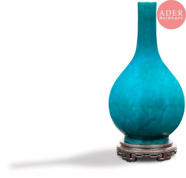 CHINE - XVIIIe siècle
Vase bouteille en porcelaine émaillée bleu turquoise.
H. : 38,5 cm. Socle en bois ajouré à décor géométrique.