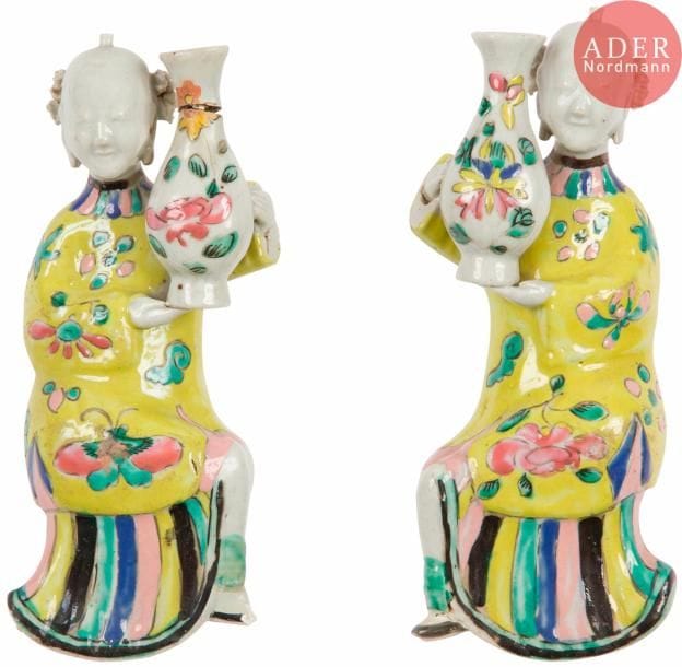 CHINE - Époque JIAQING (1796 - 1820)
Paire de vases appliques en porcelaine émaillée polychrome en forme de jeunes femmes souriantes tenant des vases. (Accidents et restaurations).
H. : 19 cm. 